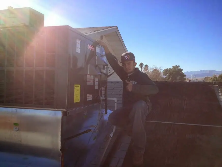 HVAC technician performing AC Tune-Up on a rooftop unit in Sitka
